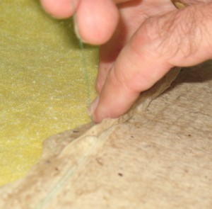Lifting the sheet edge with the thread