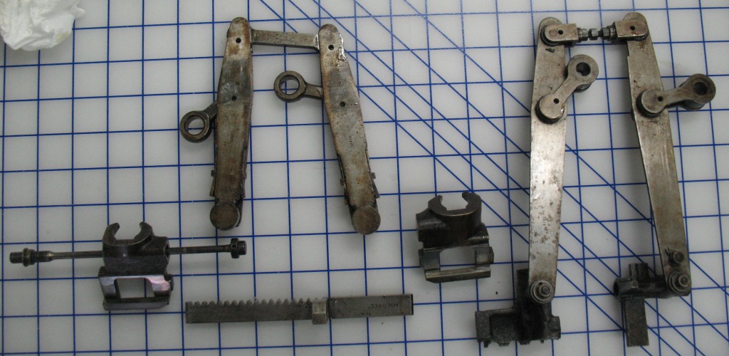 These are the parts I had to remove before I could lift the pin block cover: On the right, the pin jaws still attached to their tongs, and on the left, the rack, matrix jaws, and matrix jaw tongs.