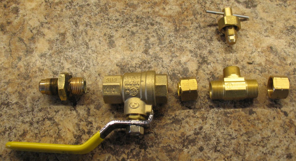 The valves I purchased. Main row (L-R) are the original supply flare fitting, the ball valve, a ⅜″ compression nut, the body of the needle value, and another ⅜″ compression nut. Above is the valve needle and cap.