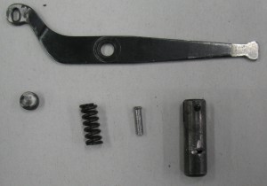 The plunger, spring, home-made rivet, and tube, all shown below one of the arms.