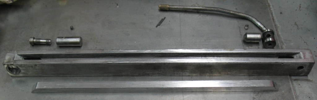 The parts of the lockup bar. Note that the main body is reversed relative to the other parts, so the eccentric near upper right actually fits into the left-hand end of the body. The insert bar goes in bevels up and two small roll pins retain it loosely.