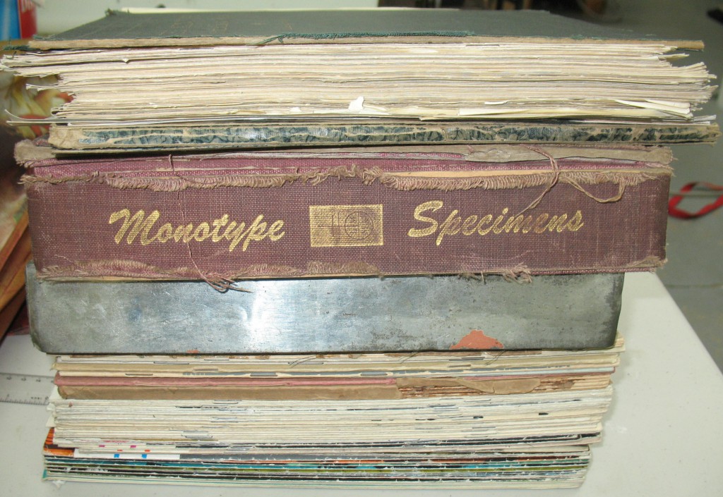 Two or three specimen books, plus a stack of periodicals.