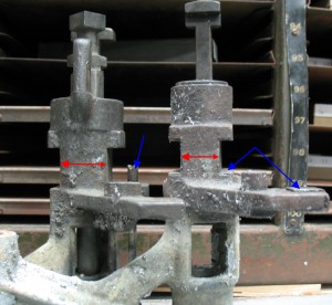 English standard pump on the right, American lead-and-rule pump on the left. Note difference in size (red arrows) as well as adjusting screw and steel wear surfaces (blue arrows).