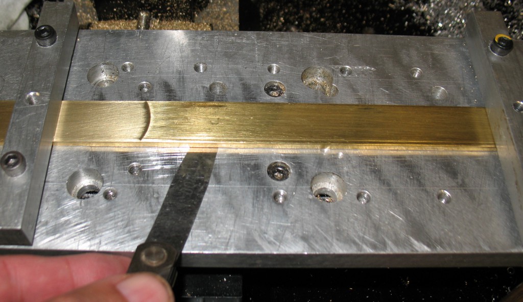 A 0.004″ feeler gauge easily slips under the brass strip near the center.