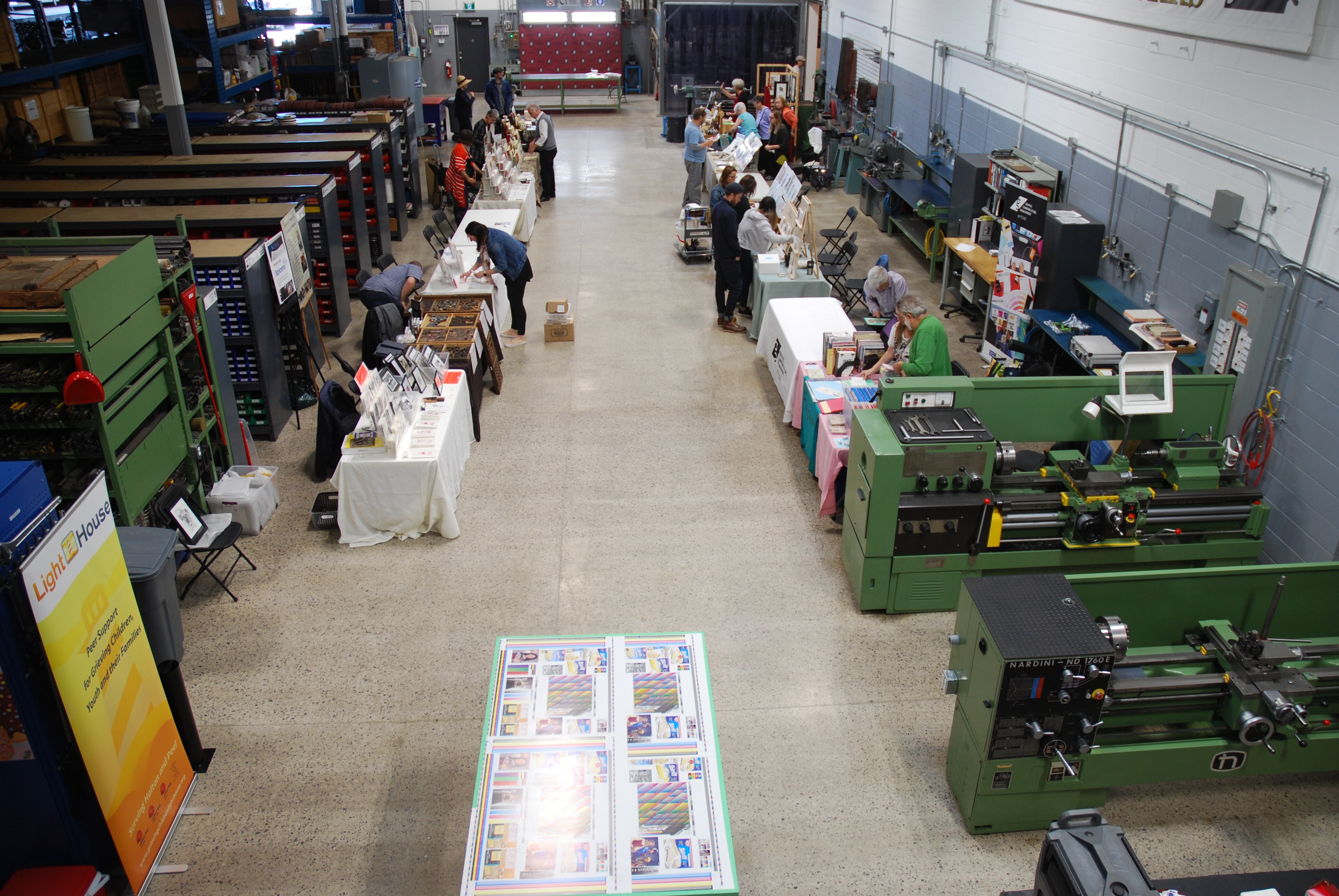 Setup time in the workshop before the fair. Our table is the first on the right, just behind the green lathe. Photo by Liana Howard.